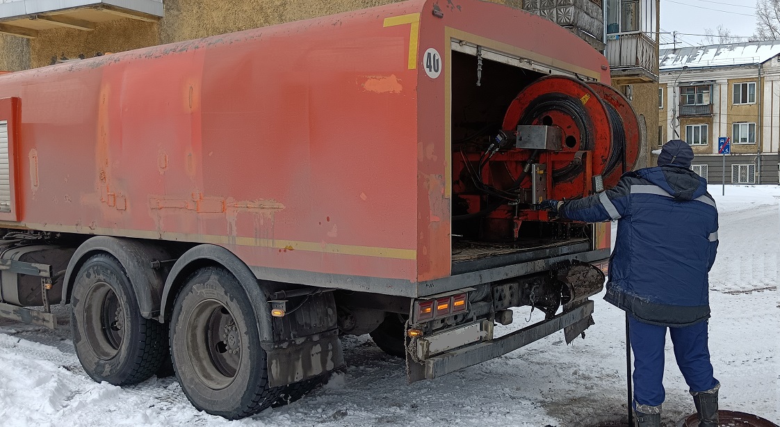 Каналопромывочная машина и работник прочищают засор в канализационной системе в Карелии