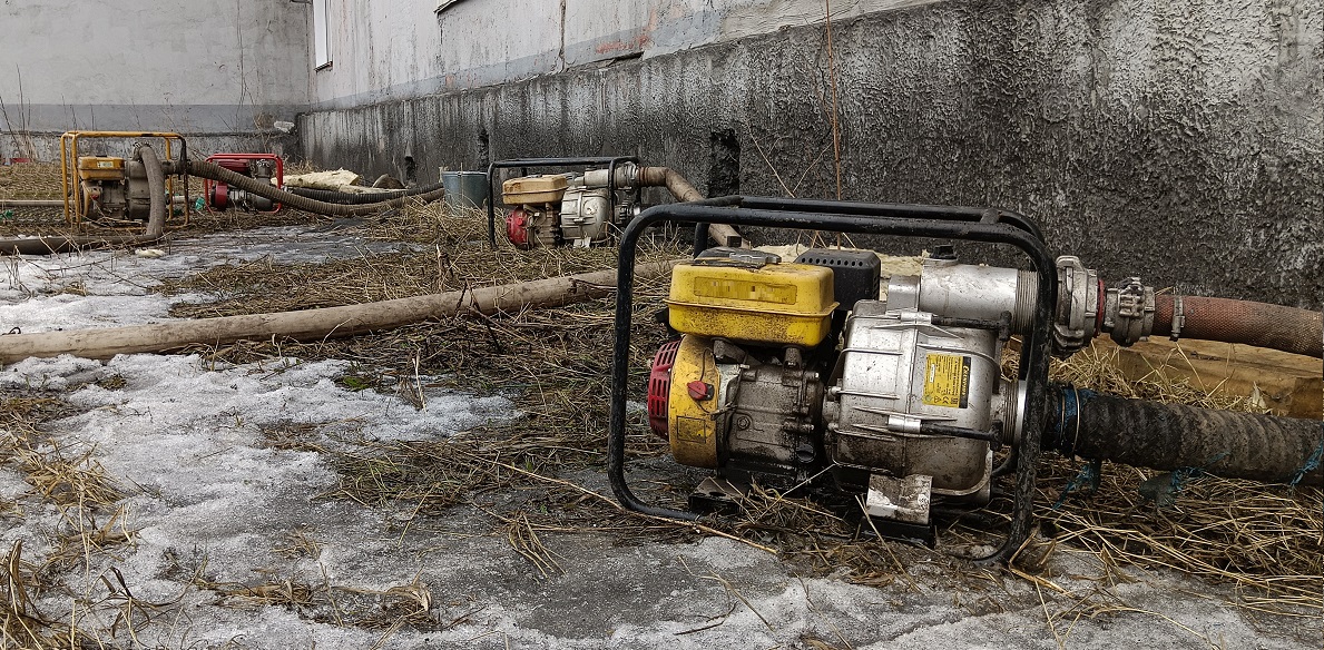 Откачка мотопомпами талой воды из подвала дома в Беломорске